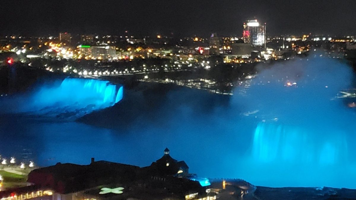 night shot with view of Niagara Falls lit up by lights